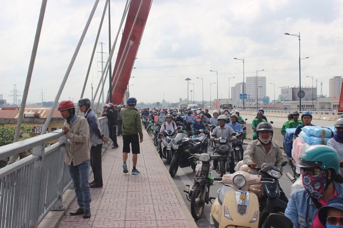 Tại cầu Bình Lợi mới, hàng trăm người dân hiếu kỳ đứng theo dõi khiến giao thông bị ùn ứ cục bộ