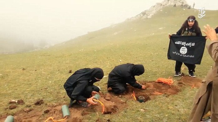Chôn bom dưới đất rồi bắt tù nhân quỳ lên trên. Ảnh: Daily Mail