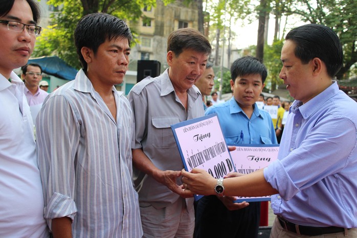 Ông Kiều Ngọc Vũ, Phó Chủ tịch LĐLĐ TP HCM, trao sổ tiết kiệm cho CNVC-LĐ  bị bệnh hiểm nghèo tại quận 5, TP HCM