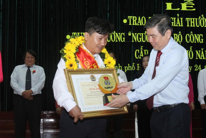 Ông Nguyễn Thành Phong - Ủy viên Trung ương Đảng, Phó Bí thư Thành ủy TP HCM - trao biểu trưng cho cán bộ Công đoàn đạt GIải thưởng 28-7   Ảnh: HOÀNG TRIỀU