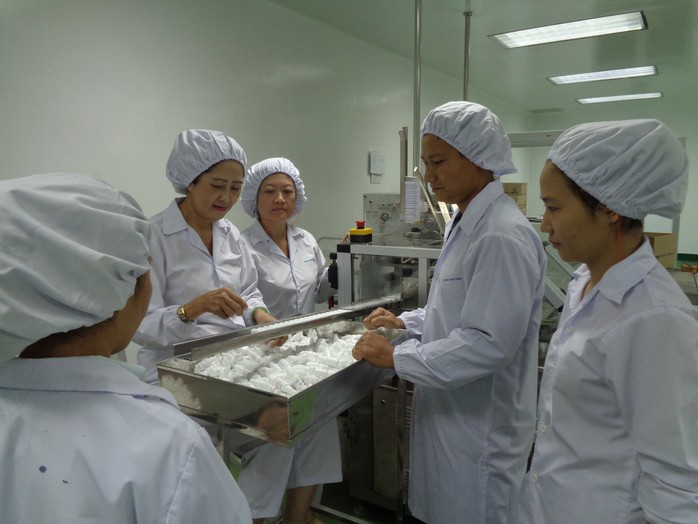 Anh Trương Quốc Hùng (thứ hai bên phải), hướng dẫn quy trình thao tác chuẩn vận hành máy cho công nhân