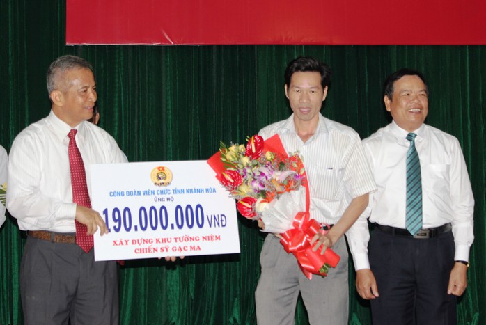 Ông Đặng Ngọc Tùng, Chủ tịch Tổng LĐLĐ Việt Nam  (bìa trái), tiếp nhận kinh phí xây dựng Khu Tưởng niệm chiến sĩ Gạc Ma từ các cấp Công đoàn tỉnh Khánh Hòa