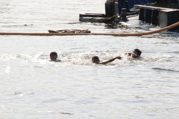 Trong khi đó, tại kênh Tẻ, nhiều trẻ nhỏ vô tư vùng vẫn trong nước mặc cho tàu bè qua lại