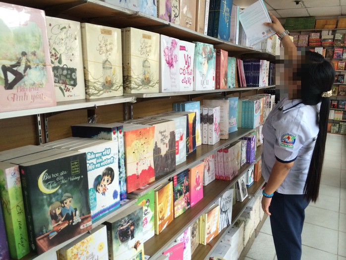 Một nữ sinh trung học tìm sách ngôn tình chất đầy trên kệ ở cửa hàng sách tại TP HCM