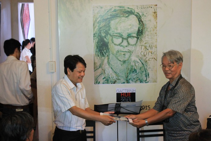 Tác giả (bìa trái) nhận ảnh sưu tập do nhà nghiên cứu Trần Viết Ngạc tặng cho Gác Trịnh                 Ảnh: PHƯƠNG ANH