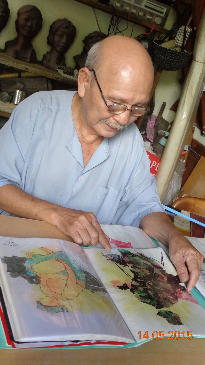 Họa sĩ Phạm Cung đang xem lại những bức tranh minh họa từ các ca khúc của Phạm Duy