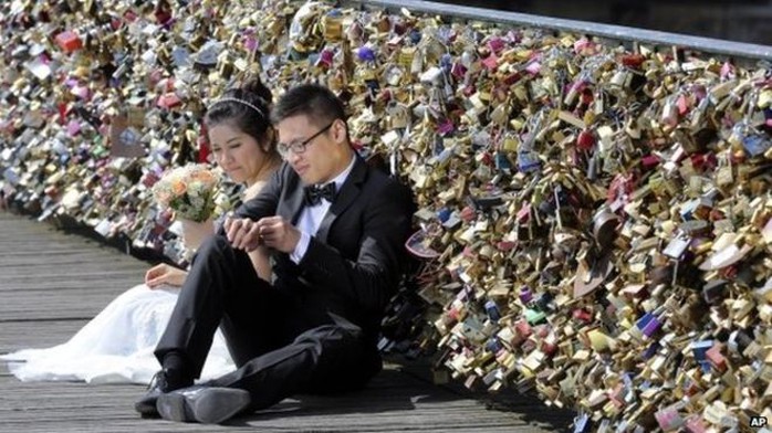 Cặp đôi chụp ảnh cưới trên cầu Pont des Arts ở Pháp. Ảnh: AP