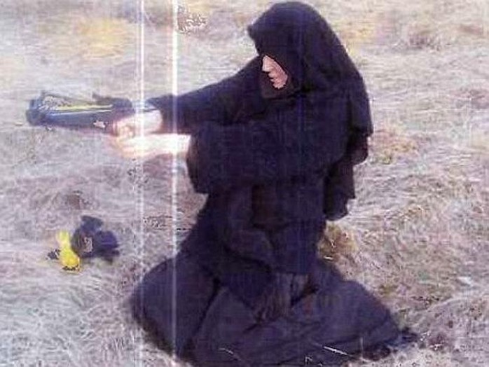 Hayat Boumeddiene trong bộ quần áo màu đen, cầm cung tên tập bắn. Ảnh: Courier Mail