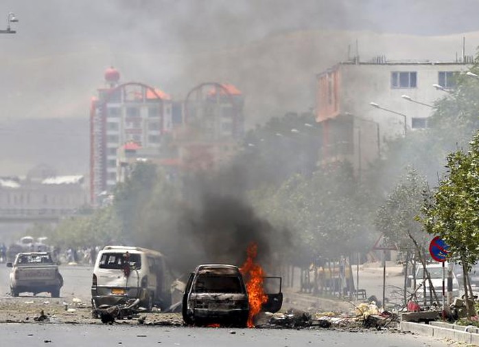 Một chiếc xe bốc cháy gần trụ sở quốc ội Afghanistan ở Kabul hôm 22-6. Ảnh: Reuters