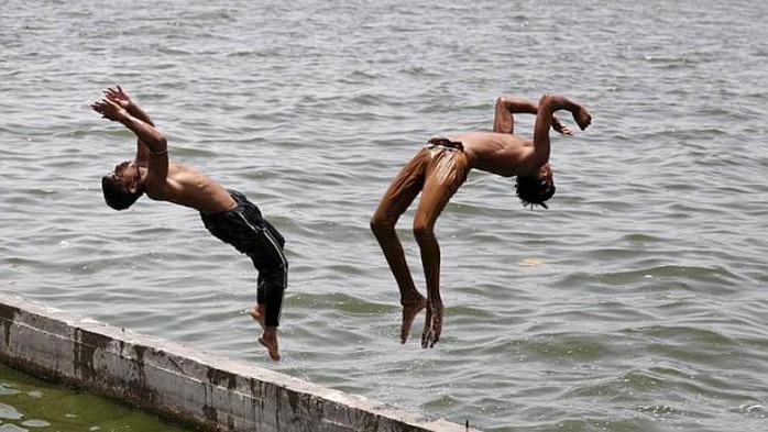 Nhảy xuống sông Sabarmati ở Ahmedabad - Ấn Độ để giải nhiệt. Ảnh: EPA