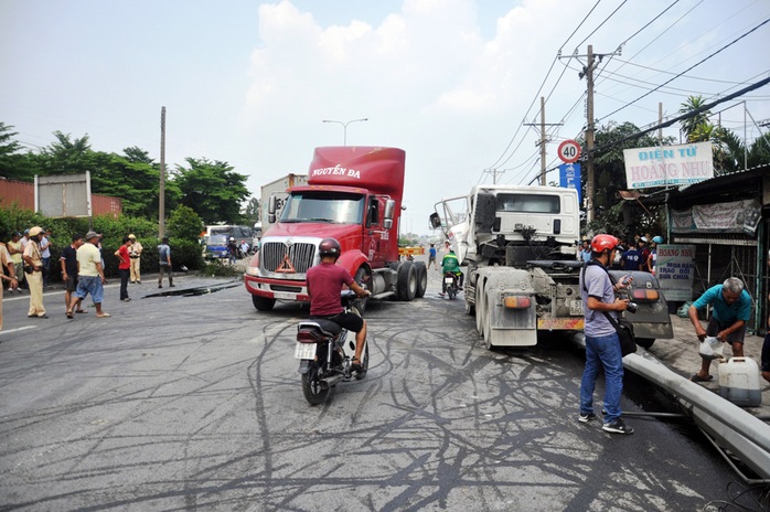 Chiếc container ủi bay cột đèn trên dải phân cách trước khi lao vào tông sập trụ mái hiên nhà dân