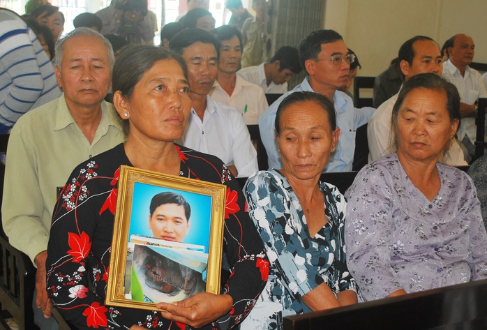 Bà Đặng Thị Nhu (mẹ ruột nạn nhân) mang theo di ảnh con trai duy nhất trong gia đình đến nghe TAND tỉnh Đồng Tháp xét xử.