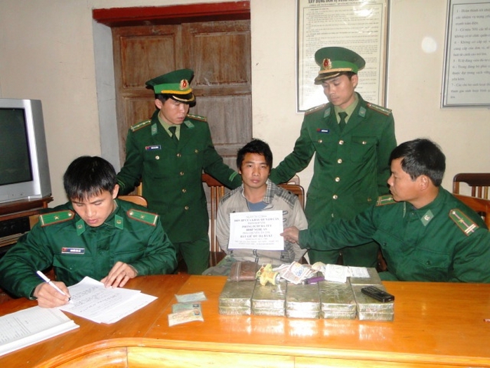 Hạ Bá Cu (giữa) cùng tang vật 20 bánh heroin bị lực lượng Bộ đội Biên phòng tỉnh Nghệ An bắt giữ  vào ngày 28-12-2014  Ảnh: Đức Ngọc