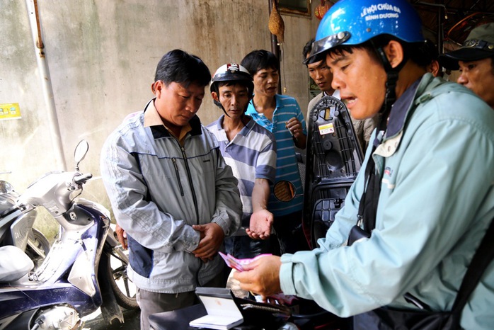 Nguyễn Văn Ngọc (trái) bị bắt cùng tang vật là 15 tờ vé số giả