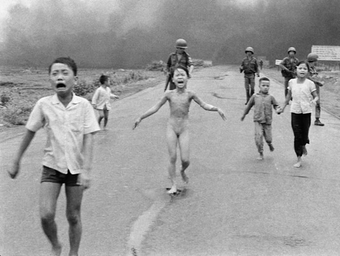 Bị bỏng nặng trong cuộc tấn công bằng bom Napalm, trẻ em chạy gào thét kêu cứu dọc đường 1 gần Trảng Bàng, phía sau là lính của Sư đoàn 25 của Việt Nam Cộng hòa ngày 8-6-1972. Cô bé Kim Phúc, 9 tuổi, (ở giữa) đã cởi quần áo bị cháy trong khi chạy. Những trẻ em khác (từ trái) là anh của cô Phan Thanh Tâm, người bị mất một mắt và Phan Thanh Phước và anh em họ Hồ Văn Bốn và Hồ Thị Ting. Bức ảnh này của Nick Ut đã giành được giải Pulitzer cho ảnh thời sự năm 1973.