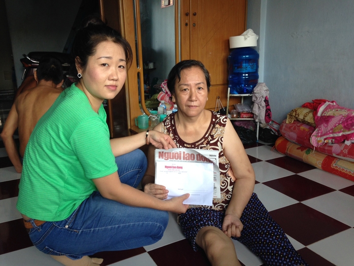 Đại diện Báo Người Lao Động trao tiền của bạn đọc giúp đỡ cho bà Trần Thị Huỳnh Hoa