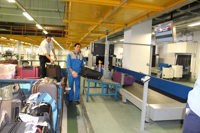 Nhân viên làm nhiệm vụ bốc xếp hành lý ký gửi tại Cảng Hàng không quốc tế Nội Bài