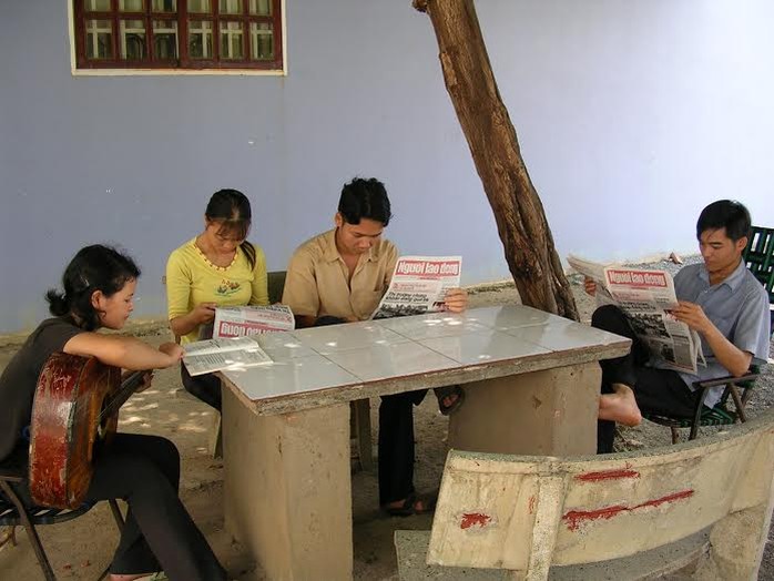 Công nhân tổ tự quản đọc báo Người Lao Động sau giờ làm việc