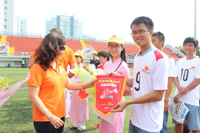 Cầu thủ Nguyễn Sỹ Đông của đội bóng đá Báo Người Lao Động nhận cờ lưu niệm của ban tổ chức