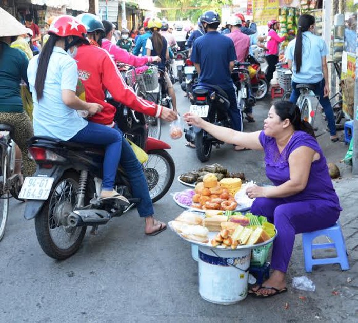 Nữ công nhân ghé mua bánh bông lan và các loại bánh ngọt    ẢNH: NGUYỄN LUÂN