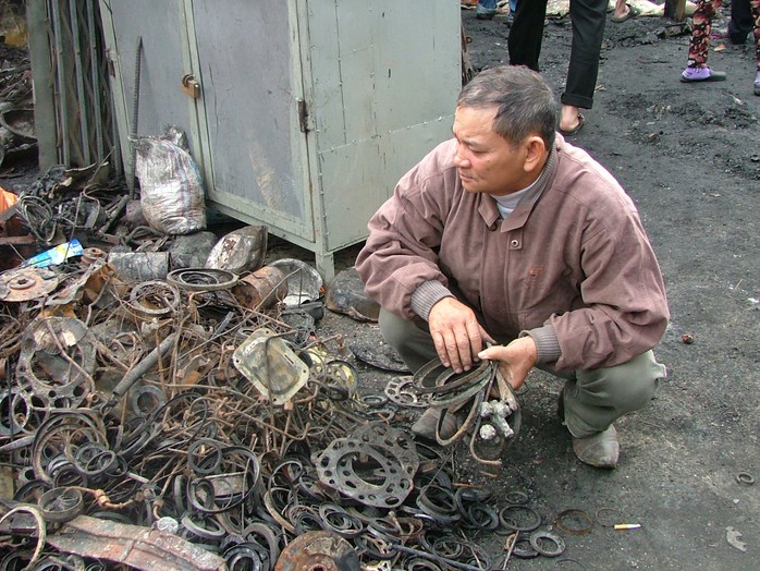 Ông Trương Văn Bình đang bới đống phế liệu tìm sổ nợ