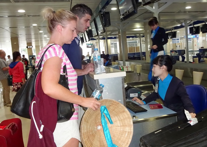 Nhân viên của Vietnam Airlines làm thủ tục cho khách tại sân bay Tân Sơn Nhất Ảnh: Tấn Thạnh