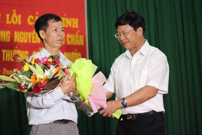 Ông Ngô Hồng Phúc, Phó Chánh Tòa Phúc thẩm TAND Tối cao tại Hà Nội (bên phải), xin lỗi và tặng hoa ông Nguyễn Thanh Chấn