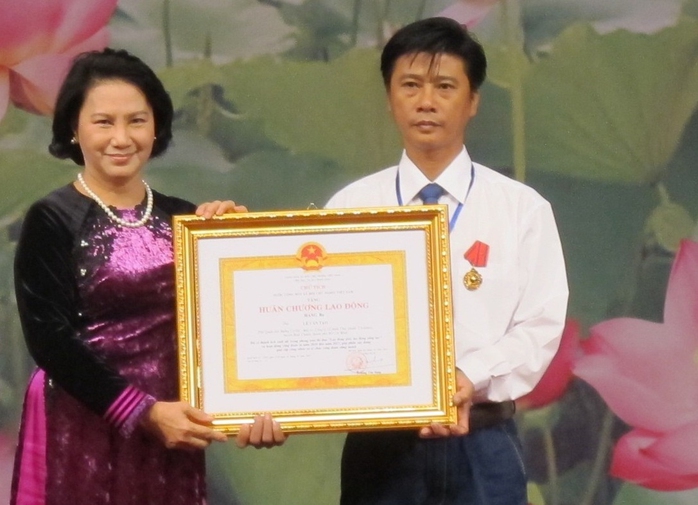 Bà Nguyễn Thị Kim Ngân - Ủy viên Bộ Chính trị, Phó Chủ tịch Quốc hội - trao Huân chương Lao động 
cho một gương điển hình