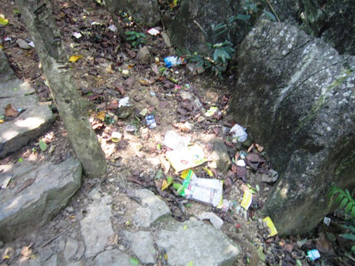 Dưới nền các phiến đá ở núi Thần Đinh các bạn trẻ vô tư vứt đồ ăn, thức uống bừa bãi