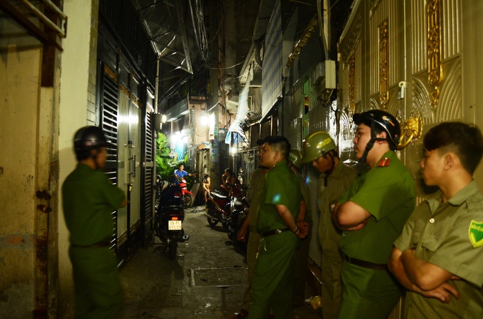Lực lượng Công an, dân quân bảo vệ trật tự trước nhà chị ve chai.