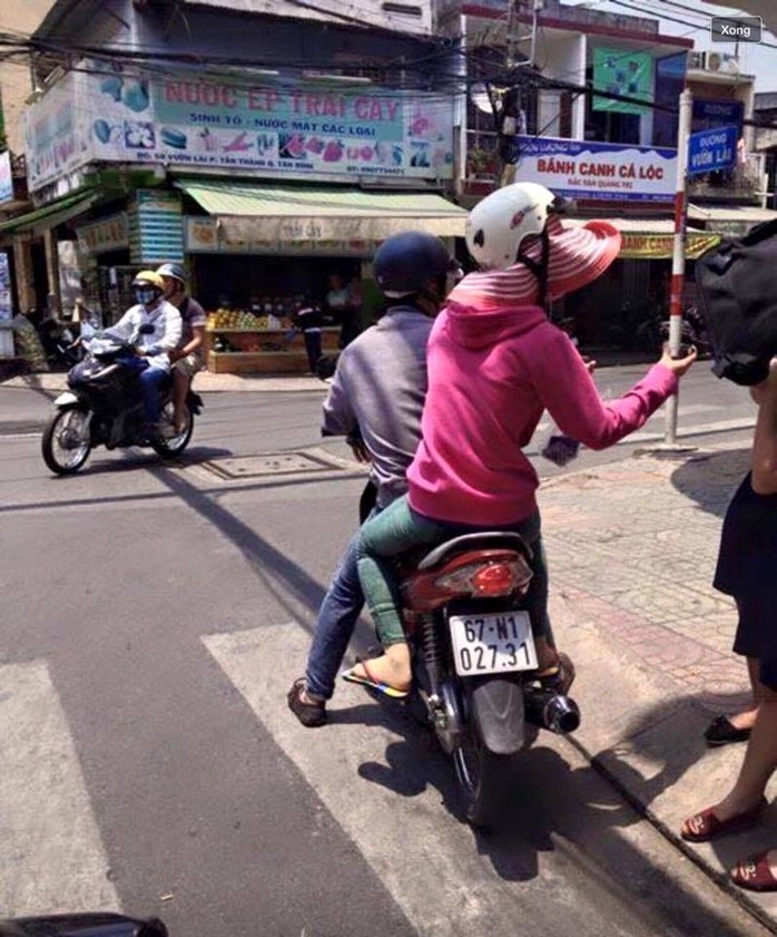 Hai nhân viên, trên xe máy thực nghiệm lại góc ảnh mà được các trang mạng lan truyền thổi phồng.