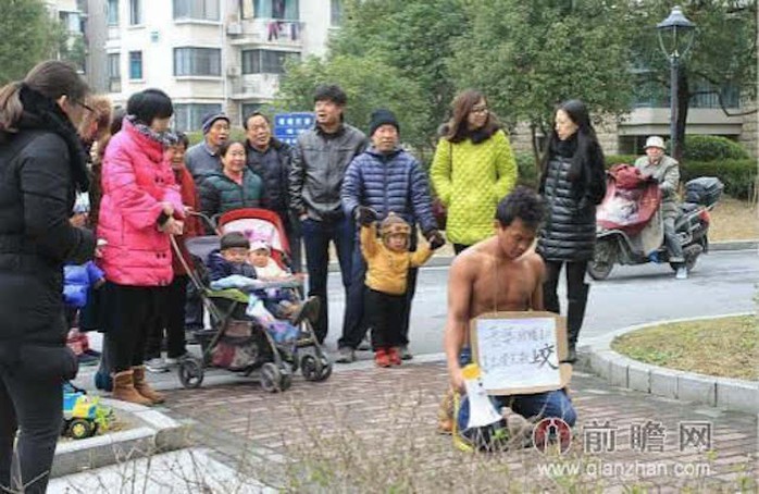 Anh Wang quỳ trước chung cư, nơi anh sống cùng vợ. Ảnh: Shanghaiist