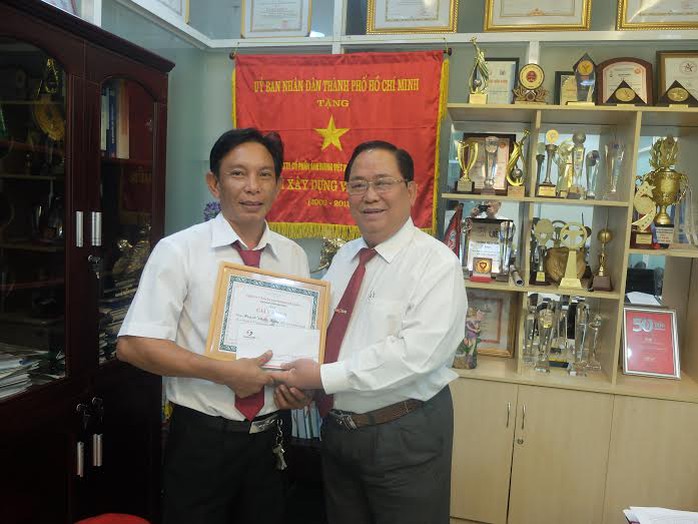 Ông Tạ Long Hỷ (bìa phải), Phó tổng Giám Đốc Vinasun, trao giấy khen và tiền thưởng cho anh Hùng