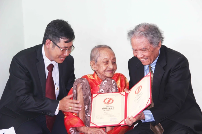  Đại diện Tổ chức Kỷ lục Việt Nam trao bằng công nhận Kỷ lục Cụ bà thọ nhất thế giới của Hiệp hội Kỷ lục Thế giới cho cụ Nguyễn Thị Trù vào sáng 9-5 (ảnh do Vietkings cung cấp)