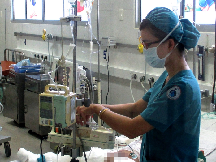 Một điều dưỡng của BV Nhi Đồng 1 đang điều chỉnh các thiết bị hỗ trợ cho bé T.