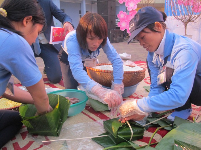 Các công nhân trổ tài thi gói bánh chưng trong chương trình Tết sum vầy.