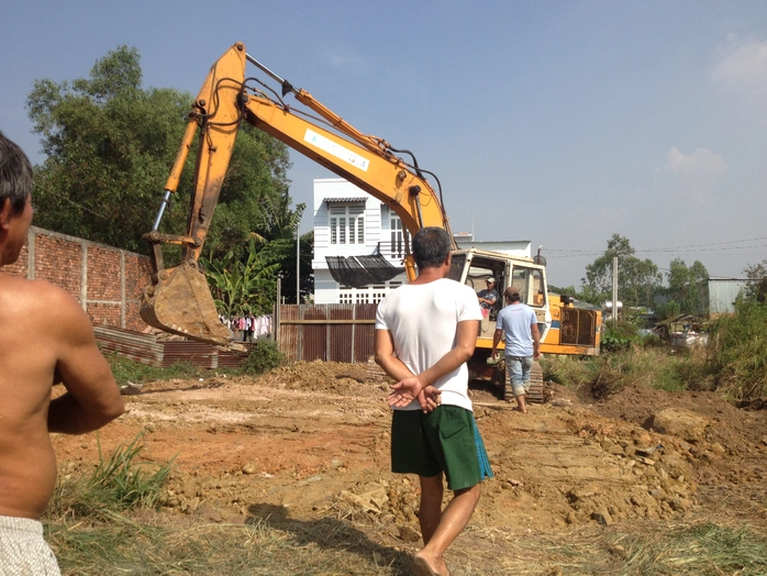 Máy xúc của công ty Đồng Xanh đào hố chôn nước thải bị người dân giữ lại