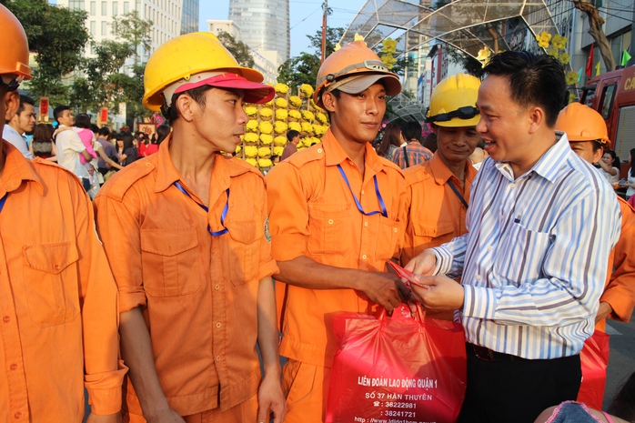 ông Trần Vũ Bình, Phó Chủ tịch LĐLĐ quận 1, TP HCM, tặng lì xì cho công nhân vệ sinh làm việc tại đường hoa Hàm Nghi