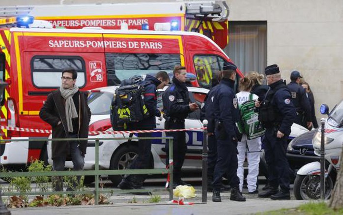 A view shows policemen and rescue members at the scene after a shooting at the Paris offices of Charlie Hebdo, a satirical newspaper, January 7, 2015.   REUTERS/Jacky Naegelen