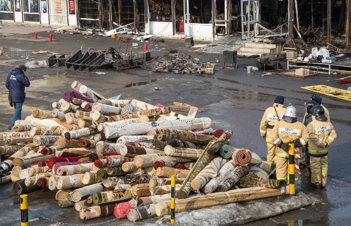 Спасатели во время разборов у сгоревшего торгового центра.