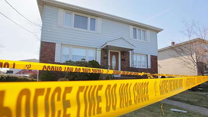 Police tape marks off a home where the bodies of an elderly couple were found Monday, Apr