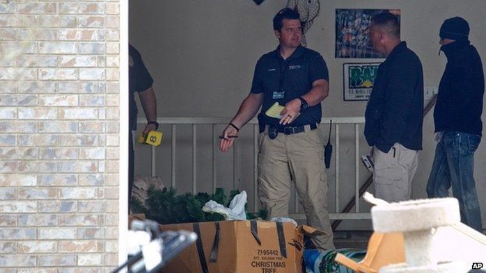Authorities investigate a crime scene where seven infant bodies were discovered and packaged in separate containers at a home in Pleasant Grove, Utah 14 April 2014