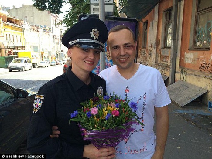 From Ukraine, with love: 2,000 new police officers have taken to the streets of Kiev today in an attempt to reform the countrys police force (pictured, a female officer hands flowers to an injured man)