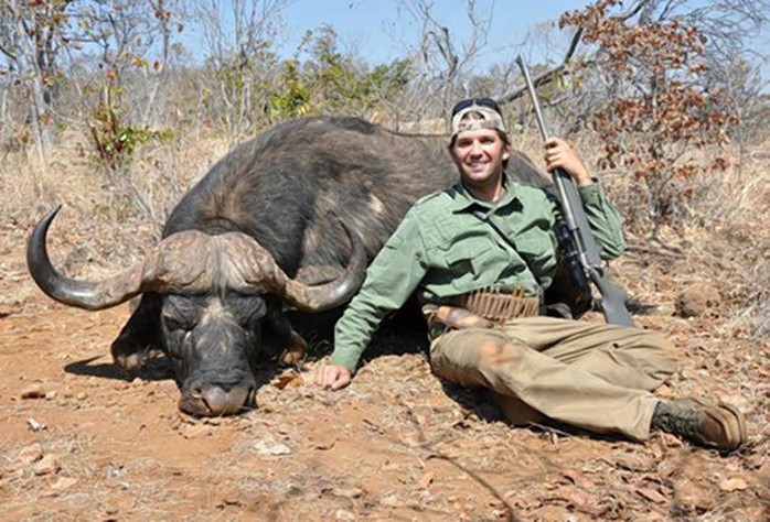 A rifle-touting Donald Trump Jr. grins next to a buffalo he killed on a trip to Zimbabwe in 2011.