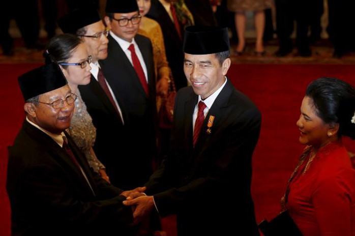 Tổng thống Joko Widodo (giữa) chúc mừng tân Bộ trưởng Kinh tế Darmin Nasution (trái) sau lễ nhậm chức hôm 12-8 Ảnh: Reuters