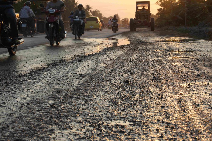 Mặt đường bong tróc, gồ ghề, đọng nước trên mặt đường trên Quốc lộ 91 đoạn qua phường Thới Long, quận Ô Môn.