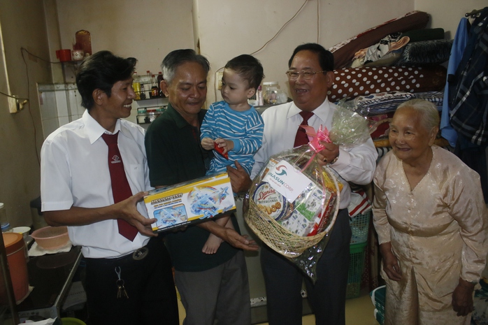 Ông Tạ Long Hỷ (thứ hai từ phải sang), Phó tổng giám đốc Vinasun, tặng quà Tết cho gia đình ông Mai Thành Liêm
