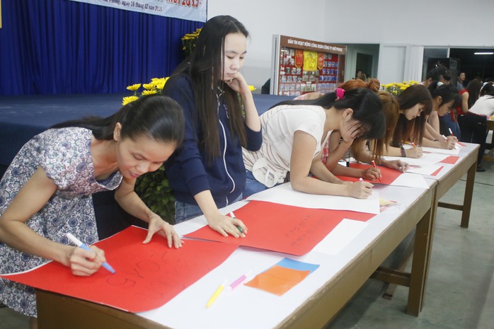Nữ công nhân Công ty Huê Phong hào hứng tham gia thi viết câu chúc Xuân trên giấy