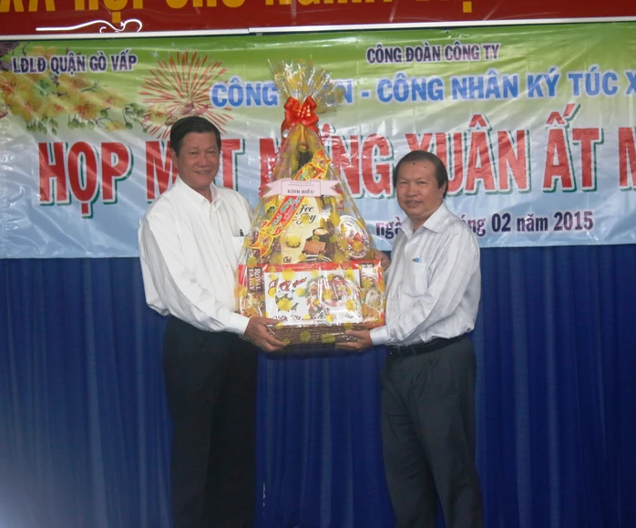 Ông Nguyễn Việt Cường (bìa phải), Phó Chủ tịch LĐLĐ TP HCM, tặng quà Têt cho ban giám đốc Công ty Huê Phong