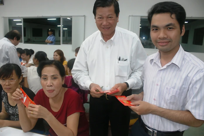 Ông Sy Sâm Cau (giữa), Phó Chủ tịch HĐQT Công ty Huê Phong lì xí Tết cho công nhân